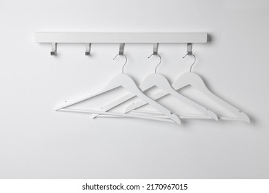 Rack With Empty Clothes Hangers On White Wall