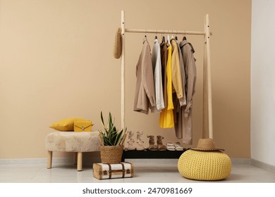 Rack with female clothes near beige wall - Powered by Shutterstock