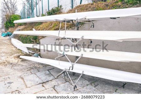 Rack holds several racing shells, known as fine boats. These long, narrow boats are designed for competitive rowing and are stored together when not in use