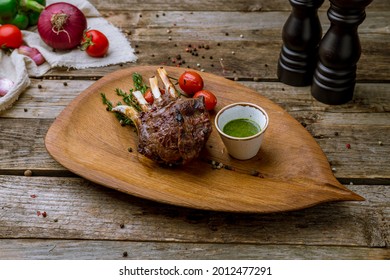 Rack Of Lamb Of New Zeland With Pesto Sause On Board On Old Wooden Table