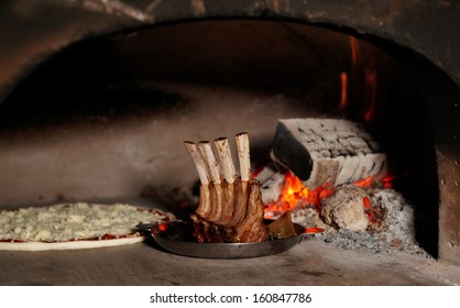 Rack Of Lamb And Pizza In Traditional Wood Fire Oven