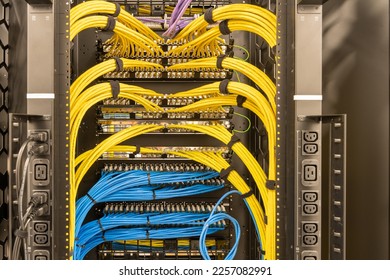 Rack with power sockets on a side, multiple switches and routers with tidily patched network cables, RJ45, data centre, networking - Powered by Shutterstock