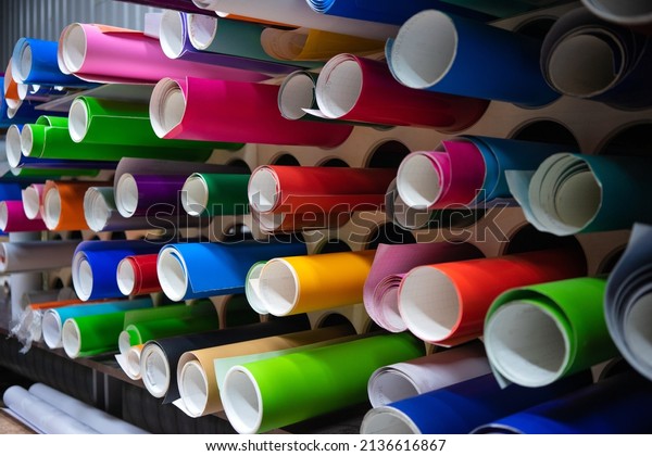 A rack\
with rolls of self-adhesive film for advertising. Vinyl film on the\
stand in the store.Advertising\
production.