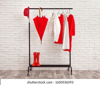 Rack with stylish clothes near white brick wall - Shutterstock ID 1650536593