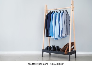 Rack With Stylish Male Clothes Near Light Wall