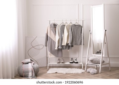 Rack avec des vêtements chauds et un miroir dans le dressing
