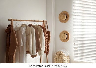 Rack with stylish women's clothes in dressing room. Modern interior design - Powered by Shutterstock