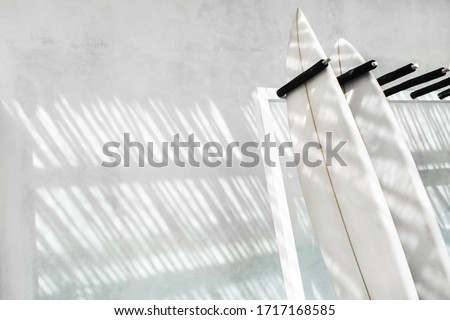 Rack with two surf boards on gray concrete background with beautiful day sun light. Active lifestyle, sports equipment.  Rent surfing board in Bali.