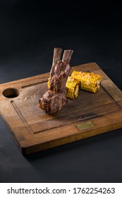 Rack von Kalbfleisch, gegrillt mit süßem Mais und auf einen Holzteller gestellt, wird als Hauptspeise im Restaurant serviert