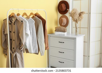 Rack with warm clothes and commode in interior of stylish hall - Powered by Shutterstock