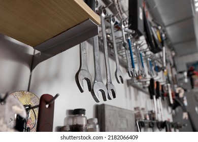 Rack With Wrenches Of Different Sizes And Other Tools Close-up In The Repair Shop. Professional Tools For Car And Bicycle Repair Are Placed On The Shelves In The Garage Workshop