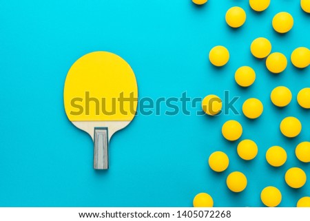 racket and many balls for table tennis on turquoise blue background. flat lay image of many table tennis balls and paddle. minimalist photo of yellow ping-pong equipment