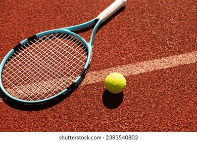 Racket with a tennis ball on a red clay court. - Powered by Shutterstock