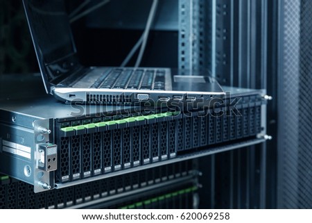 Rackmount many hard disks drive in enclosure in the storage system and notebook in the data center