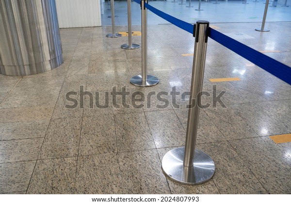 Racks, barriers to\
control the crowd of passengers at the airport. Tape Security at\
the  Airport Terminal