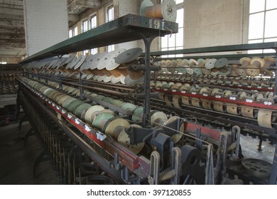 Racks of empty thread spools inside turn of the century silk throwing factory.