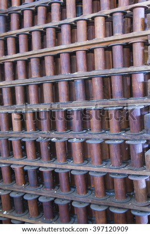 Racks of empty wooden spools in turn of the century silk throwing factory.