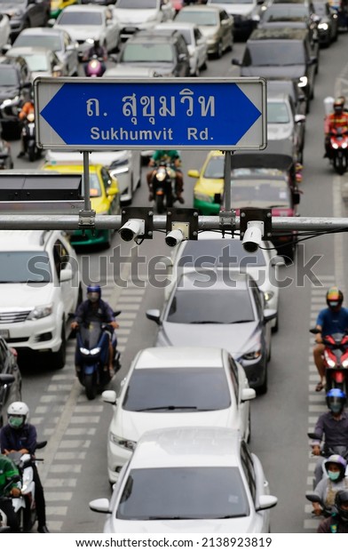 Radar speed monitoring cameras are\
seen next to the Sukhumvit road sign to control drivers and\
motorcyclists in Sukhumvit road, city of Bangkok,\
Thailand.