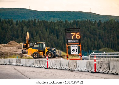 Radar Speed Sign Displays Vehicle Speed On Variable Sign, Your Speed Is 76, 80km Maximum Limitation, Road Work Zone Machines Excavators On Background