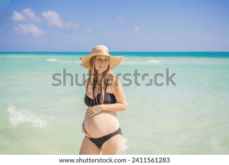 Radiant and expecting, a pregnant woman stands on a pristine snow-white tropical beach, celebrating the miracle of life against a backdrop of natural beauty