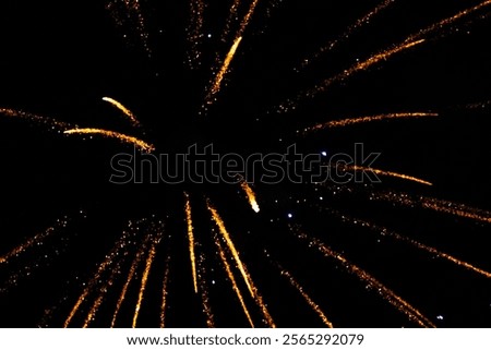 Radiant golden fireworks exploding in a dark night sky.