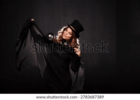 Radiant Illusionist Performs a Spellbinding Show, Conjuring Wonder With Her Silver Orb. A captivating illusionist in a striking stage costume and top hat reveals a shimmering silver orb.