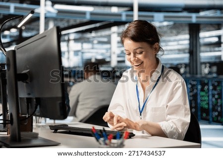 Radiant programmer in data center excited by infrastructure health report showing stable performance indicators. Overjoyed woman in server farm delighted after successfully completing operations