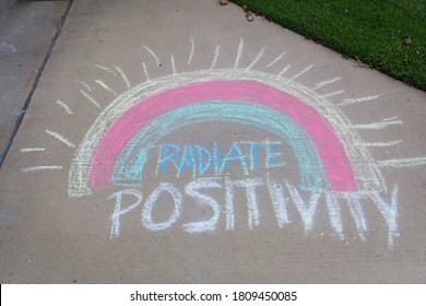 Radiate Positivity Written With Sidewalk Chalk With A Rainbow