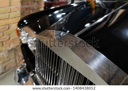 Radiator grill and headlights of black vintage classic car in Berlin in Germany. Details of auto