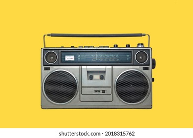 RADIO CASSETTE PLAYER ISOLATED ON YELLOW BACKGROUND. URBAN MUSIC FASHION FROM THE EIGHTIES.