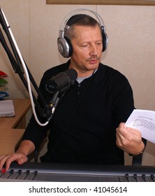 Radio DJ. Man With Microphone And Big Headphone.