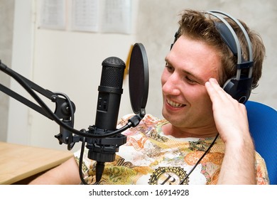 Radio DJ.  Young Man With Microphone And Big Headphone.