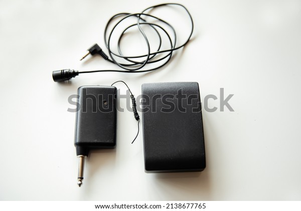 Radio microphone buttonhole on a light\
background. Receiver and transmitter. Equipment for reporting and\
videography.