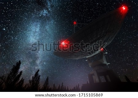 Radio telescope, a large satellite dish against the night sky tracks the stars. Technology concept, search for extraterrestrial life, wiretap of space. Mixed medium, copy space