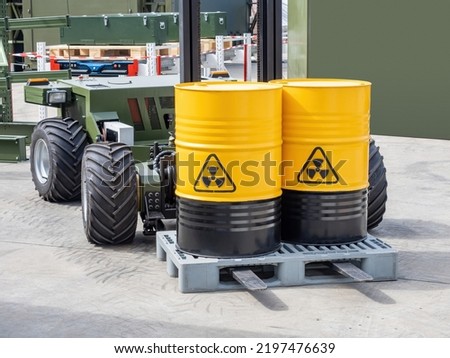 Radioactive hazard. Yellow barrels on forklift. Containers with dangerous liquid. Transportation and loading of radioactive substances. Barrels with radioactive symbol. Unmanned forklift with barrels