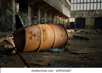 Radioactive warning on old rusty barrel in destroyed and forgotten building. Radiation symbol with russian alert on waste container after nuclear disaster.