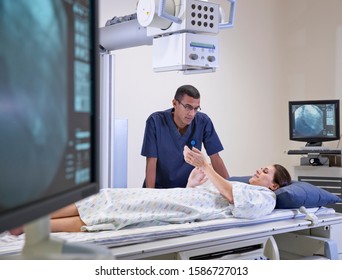 Radiographer With Female Patient In Hospital X Ray Department