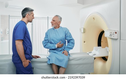 Radiologic technologist listening to senior patient's complaints sitting on CT scanner bed. Computed Tomography with contrast - Powered by Shutterstock