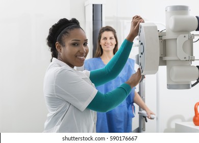 Radiologist Adjusting X-ray Machine Over Woman In Hospital