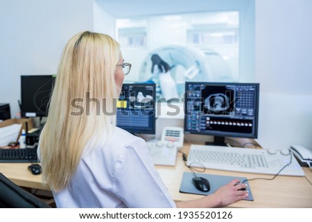 Radiologist in the control room of computed tomography at hospital