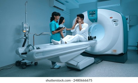 Radiologist discussing results of x-ray scan with patient. Magnetic resonance imaging scanner table after X-ray examination of biopsy in modern clinic. Positron emission tomography. - Powered by Shutterstock