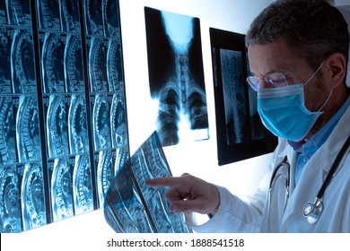 Médico radiólogo con máscara facial que examina la columna vertebral por radiografía, radiografía y resonancia magnética en el hospital. Examen y diagnóstico médicos. Concepto de atención de la salud.