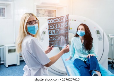 Radiologist With A Female Patient Wearing Protective Masks Examining A CT Scan