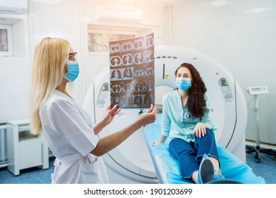 Radiologist With A Female Patient Wearing Protective Masks Examining A CT Scan