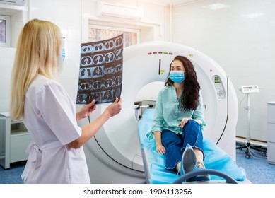 Radiologist With A Female Patient Wearing Protective Masks Examining A CT Scan