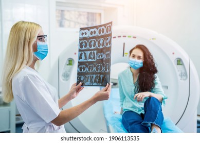 Radiologist With A Female Patient Wearing Protective Masks Examining A CT Scan