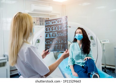 Radiologist With A Female Patient Wearing Protective Masks Examining A CT Scan