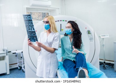 Radiologist With A Female Patient Wearing Protective Masks Examining A CT Scan