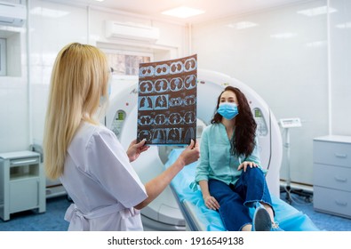 Radiologist With A Female Patient Wearing Protective Masks Examining A CT Scan