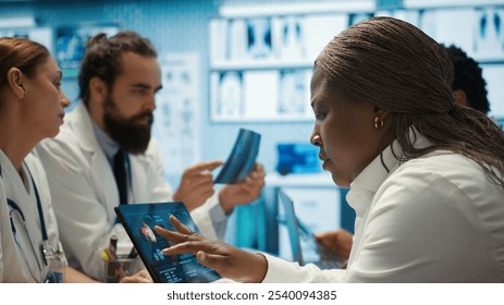 Radiologists diverse team reviewing x rays to discuss patient care in a facility. Team of skilled healthcare specialists working together to provide accurate diagnosis and treatment plans. Camera B. - Powered by Shutterstock